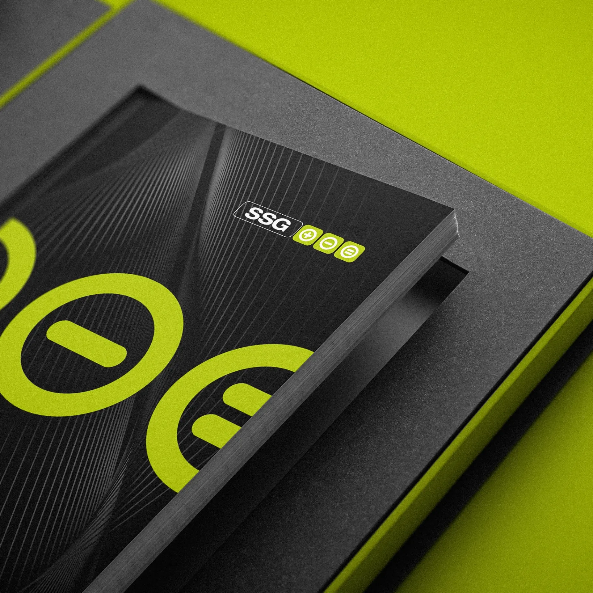 Black and lime green design on a booklet; the top booklet has the letters 