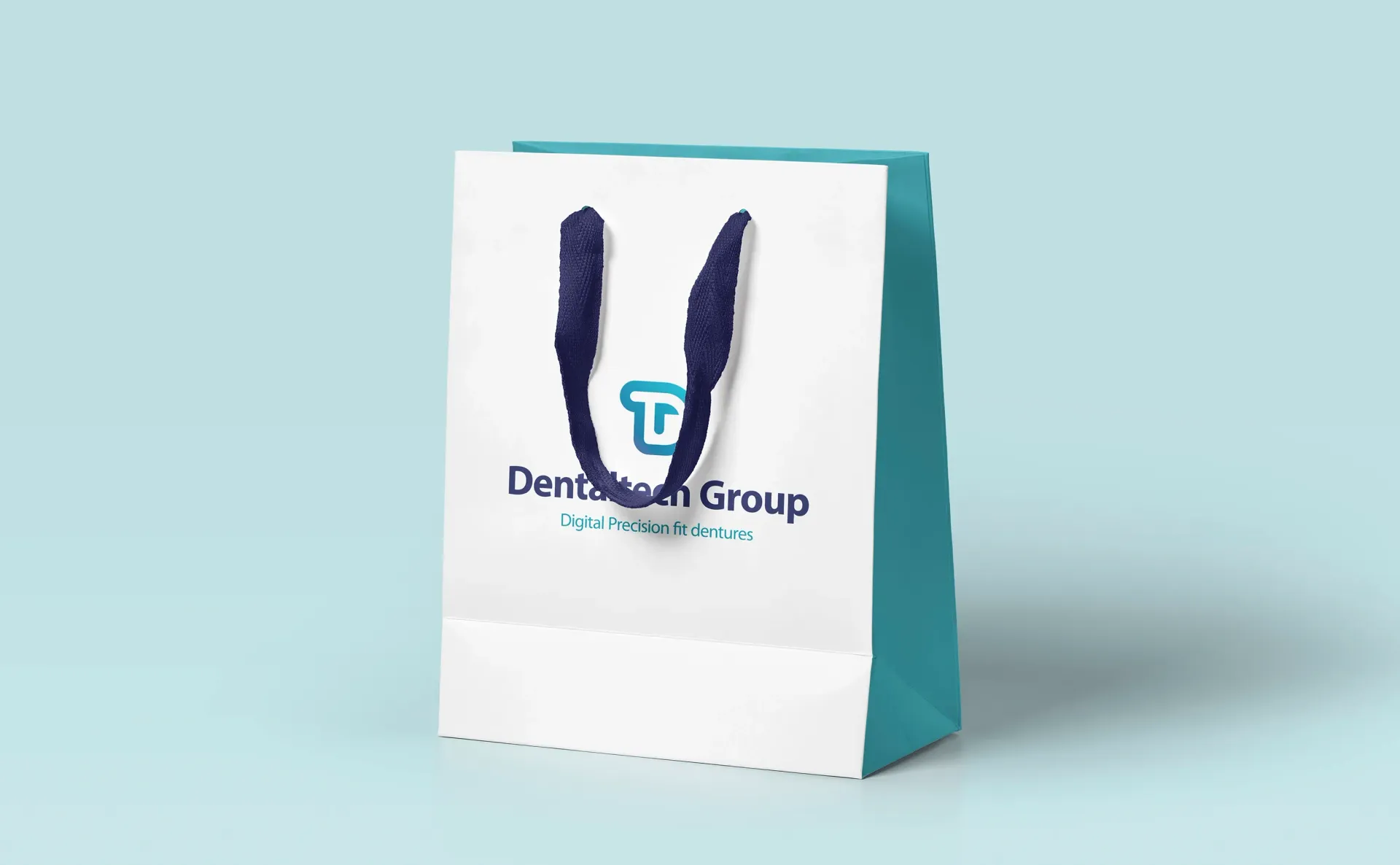 White shopping bag with teal sides and navy handles, printed with 