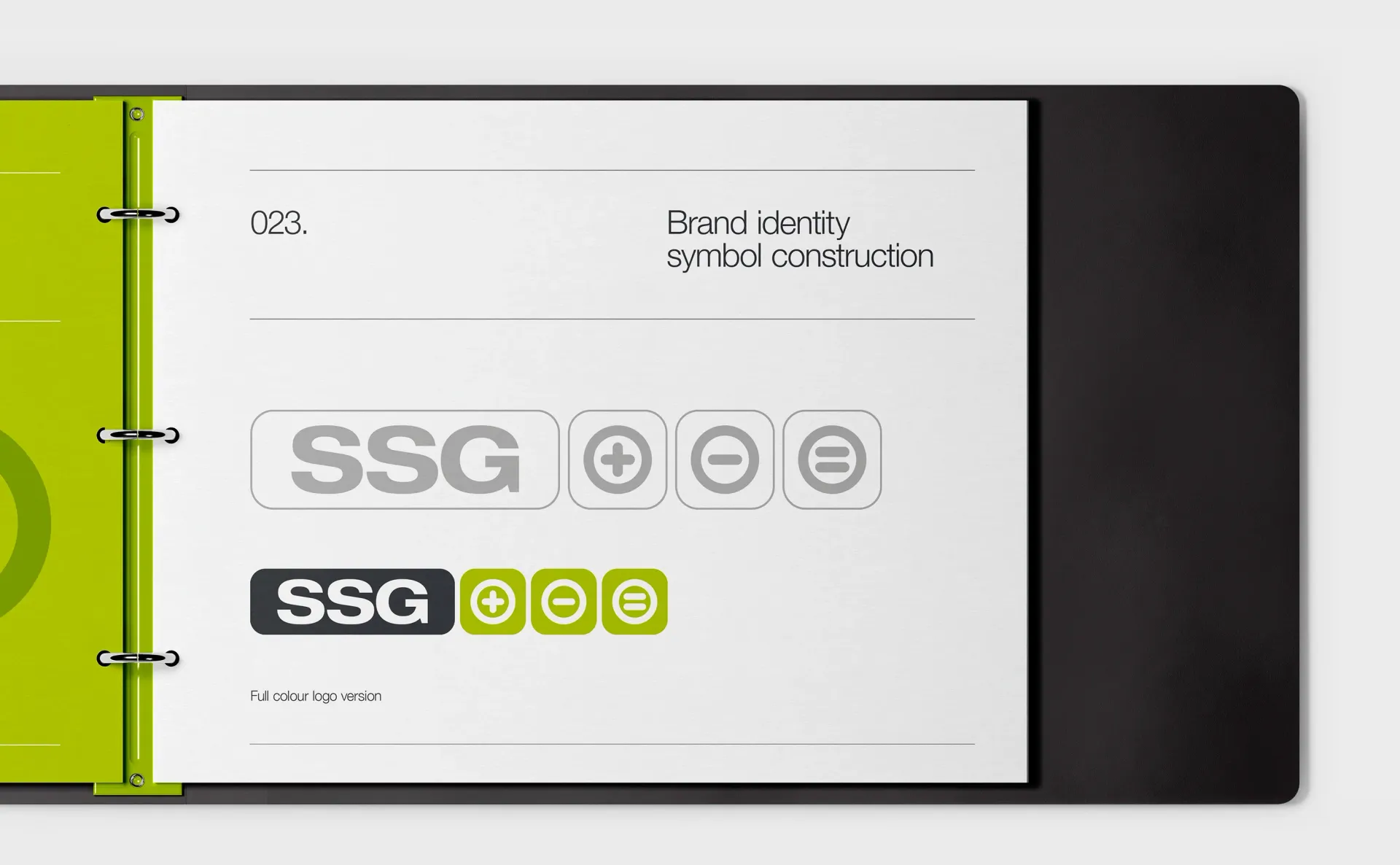 Open binder with a presentation page showing SSG logo variations, with green and gray elements.