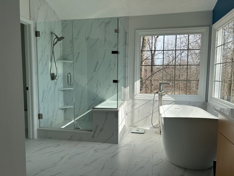 Glass shower with white and blue tile accents, silver fixtures.