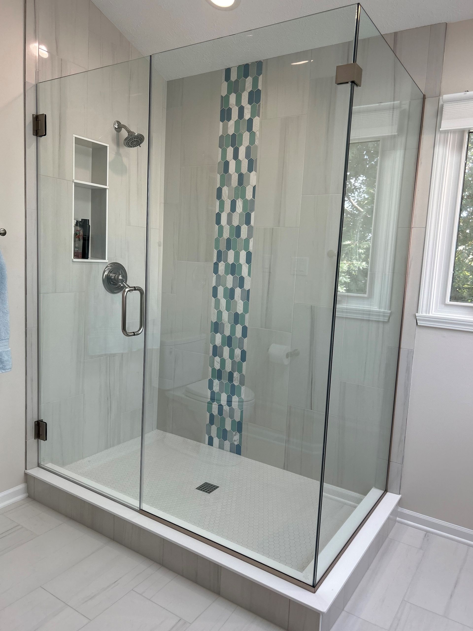 Tiler places a tile on a part of a bathroom floor with cement, as he renovates the space.