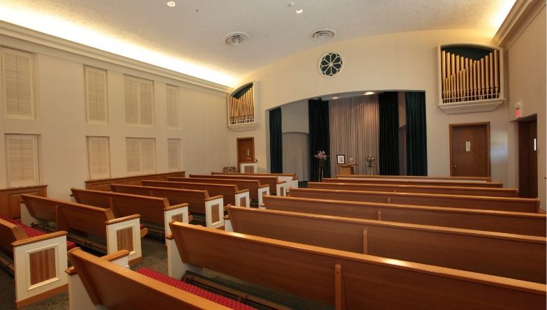 An empty church with wooden benches and a clock on the wall