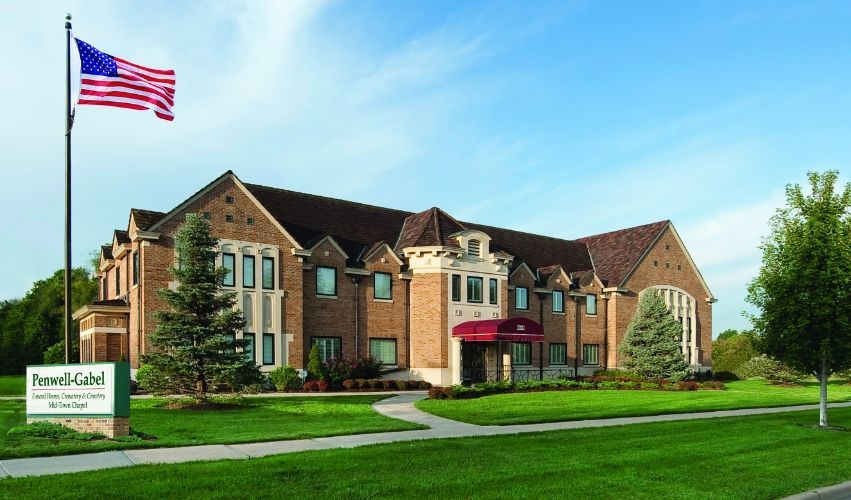 A large brick building with an american flag in front of it