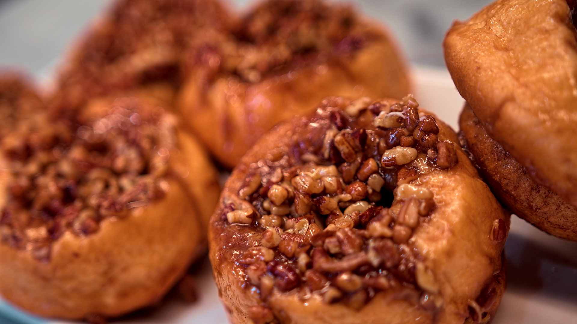 A plate of croissants with powdered sugar on a checkered table cloth.