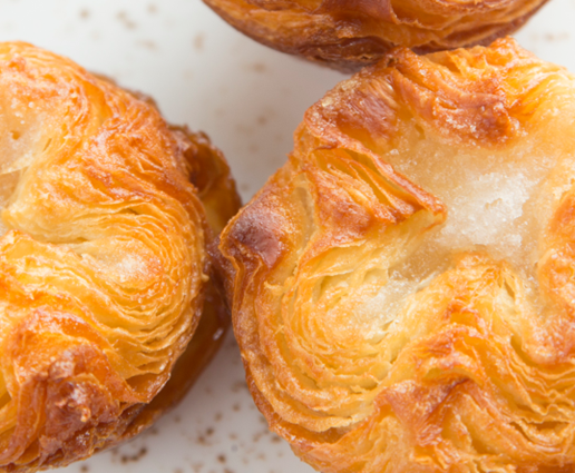 A bunch of croissants are sitting on top of each other on a table.