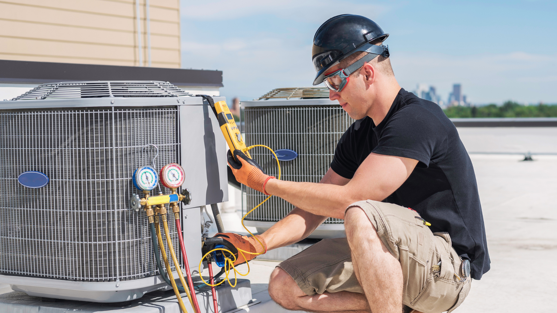 a man is working on an air conditioner on the roof of a building .
