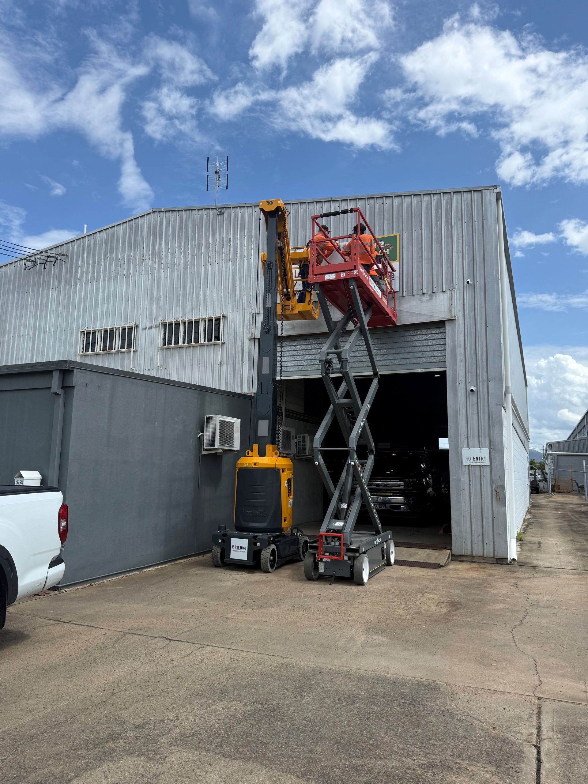 Three Scissor Lifts Are Parked Next To Each Other In A Parking Lot — B2B Hire In Garbutt, QLD