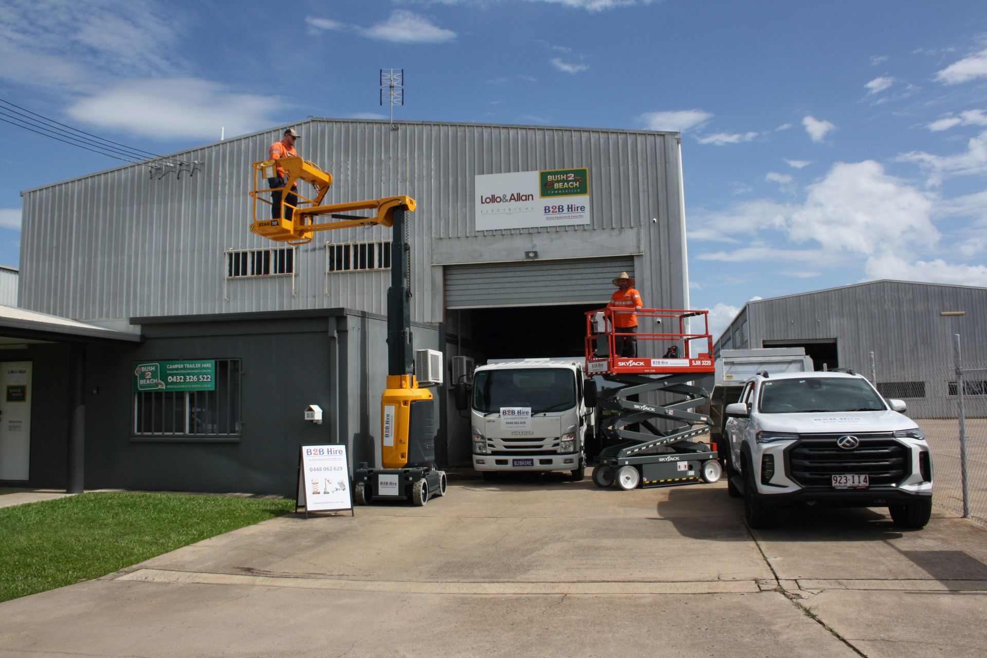 A Yellow And Orange Aerial Lift Is Parked In Front Of A Building Under Construction — B2B Hire In Garbutt, QLD