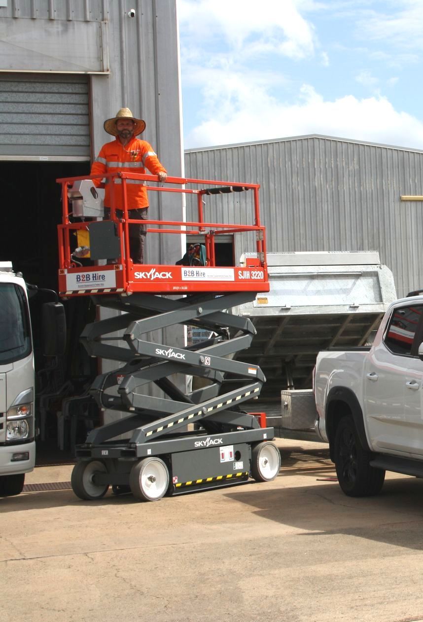 A Scissor Lift Is Parked In An Empty Warehouse — B2B Hire In Garbutt, QLD