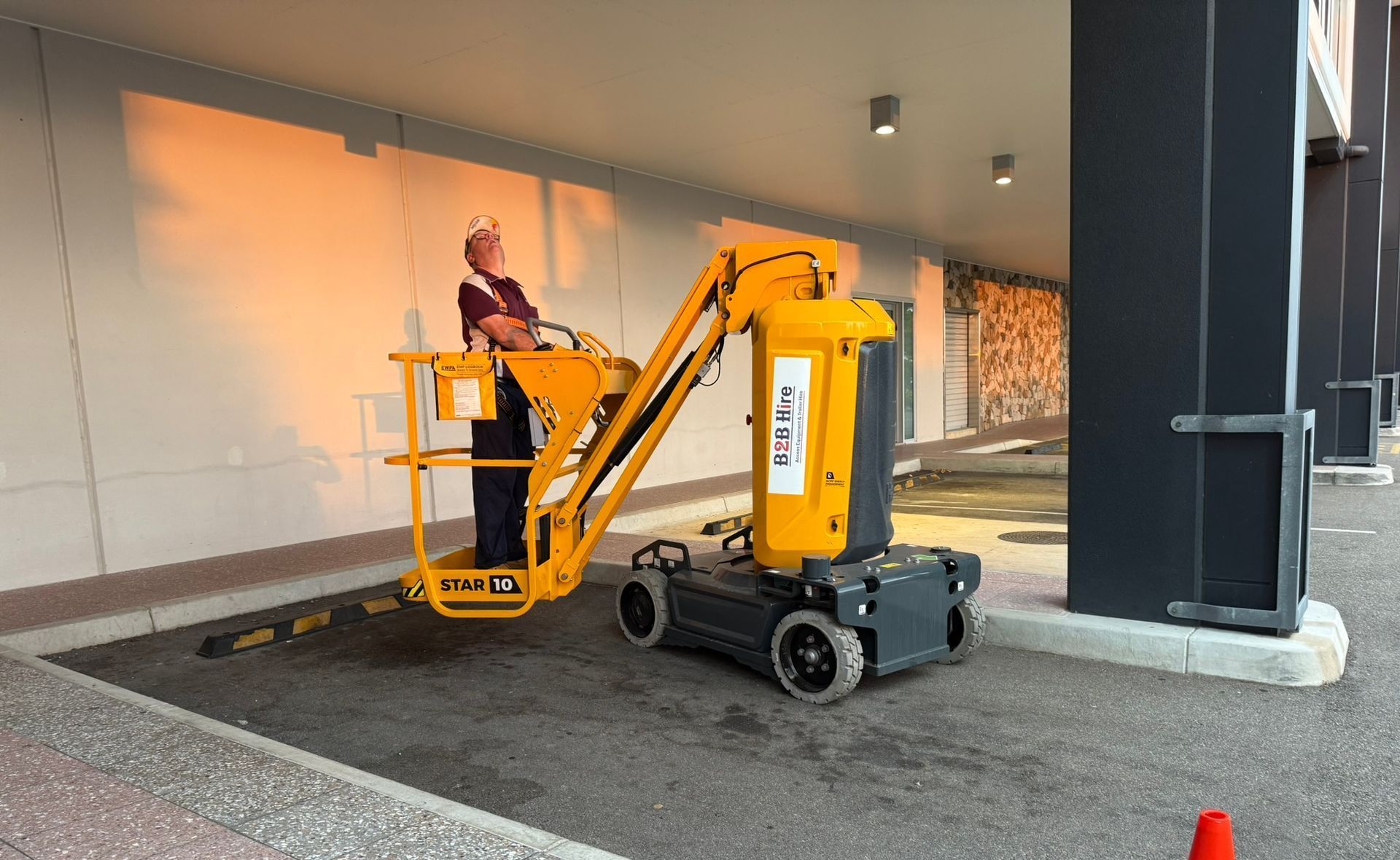 Two Construction Workers Are Working On A Building With A Crane — B2B Hire In Garbutt, QLD