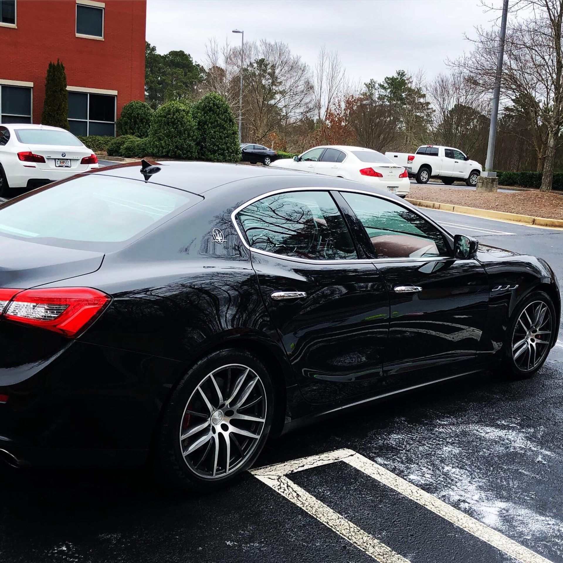A black car is parked in a parking lot