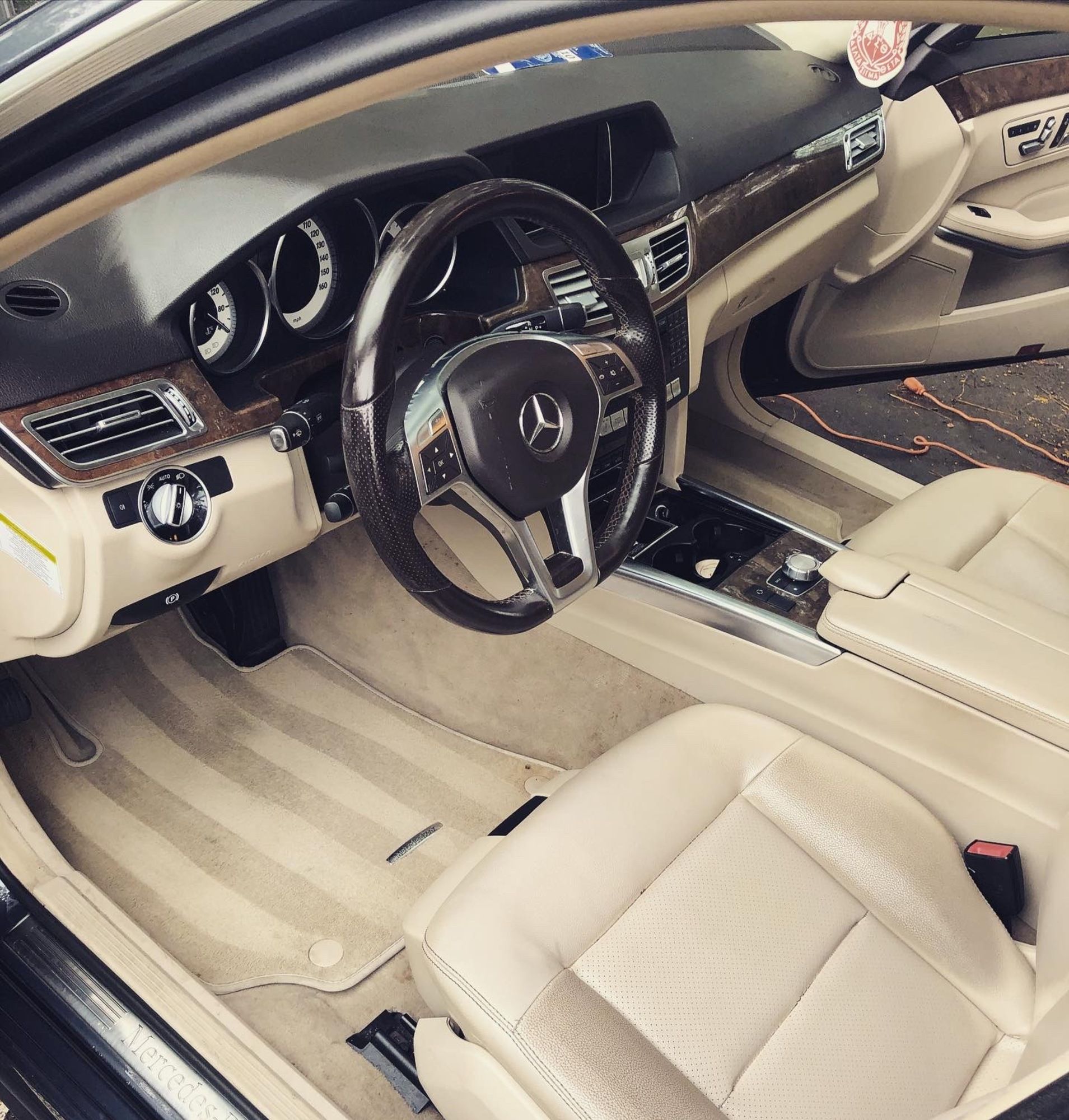The inside of a car with a mercedes logo on the steering wheel