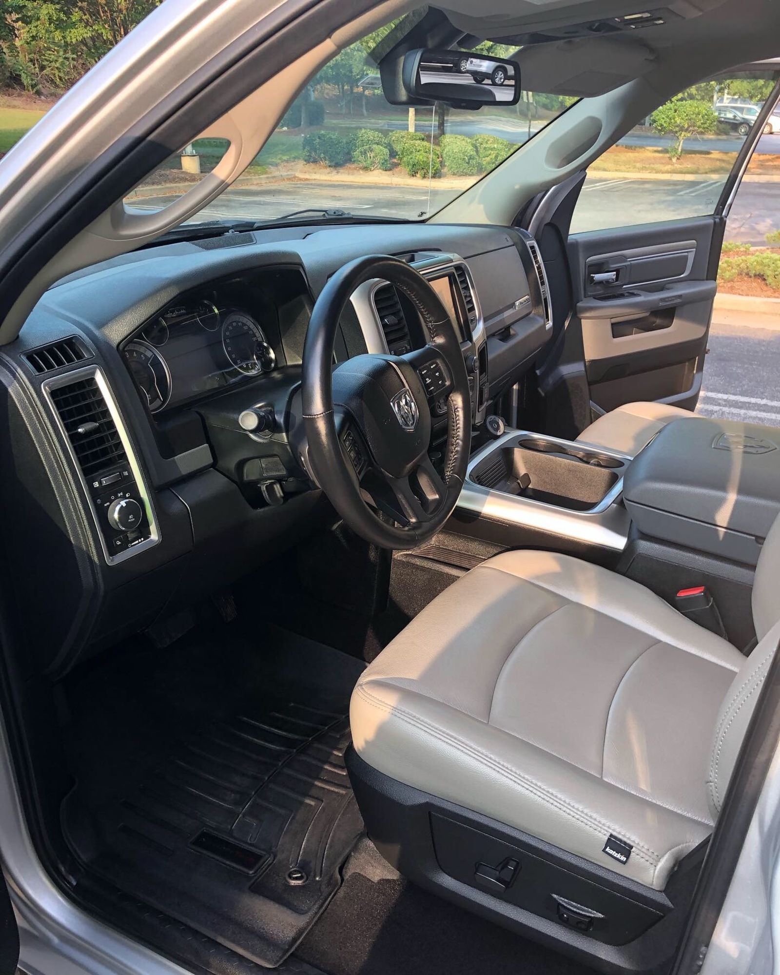 The interior of a silver dodge ram truck with the door open.