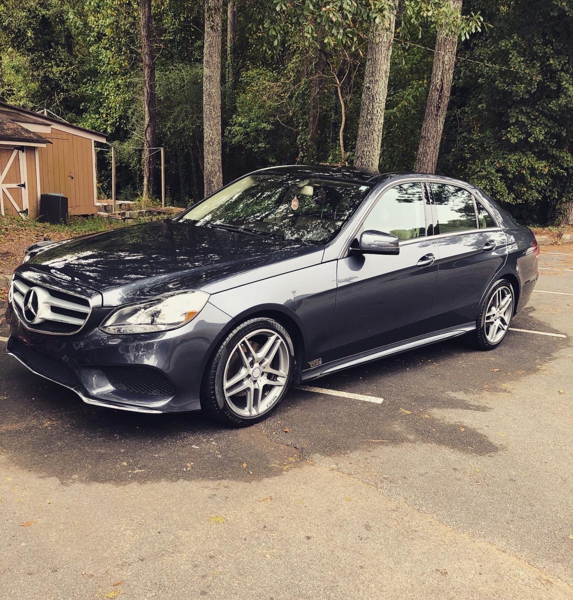 A black mercedes benz is parked in a parking lot
