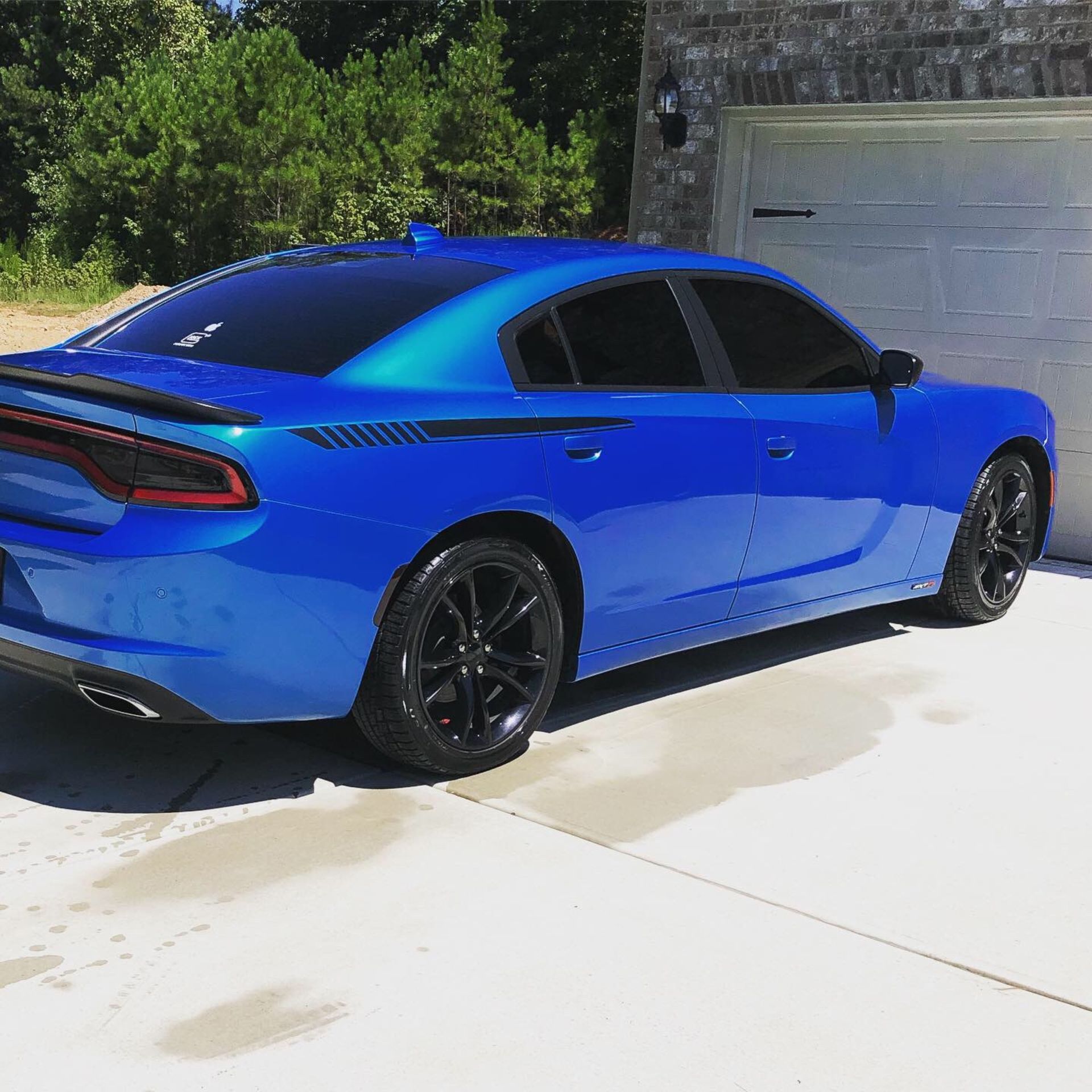 A blue car is parked in front of a garage door