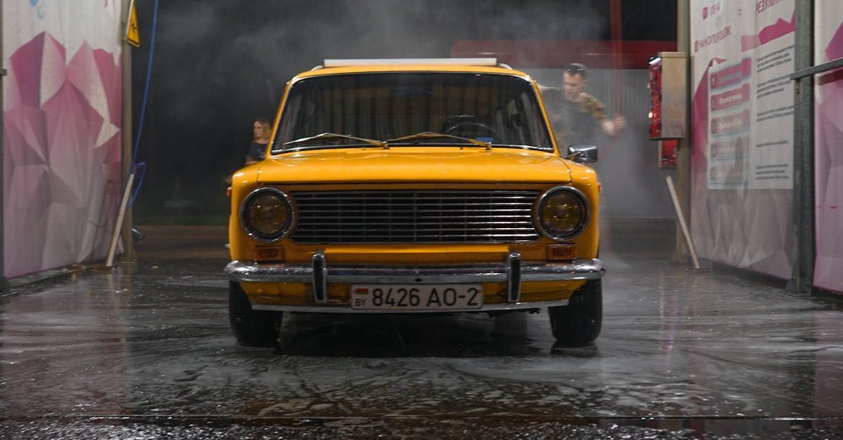 A yellow car is being washed in a car wash.