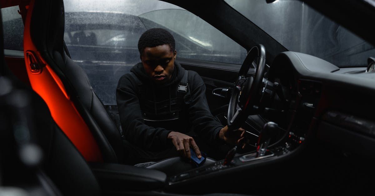 A man is sitting in the driver 's seat of a car.