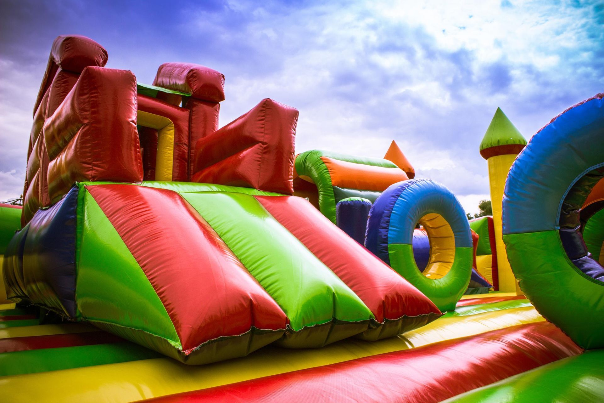 a colorful bouncy house with a castle and a slide