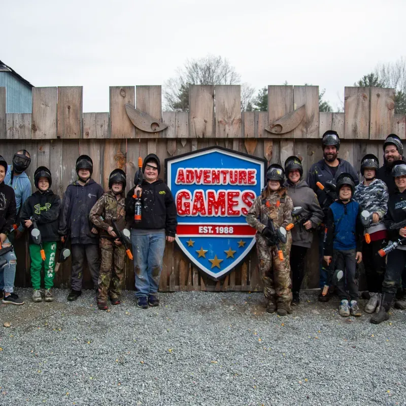 A group of people in paintball gear stand in front of an