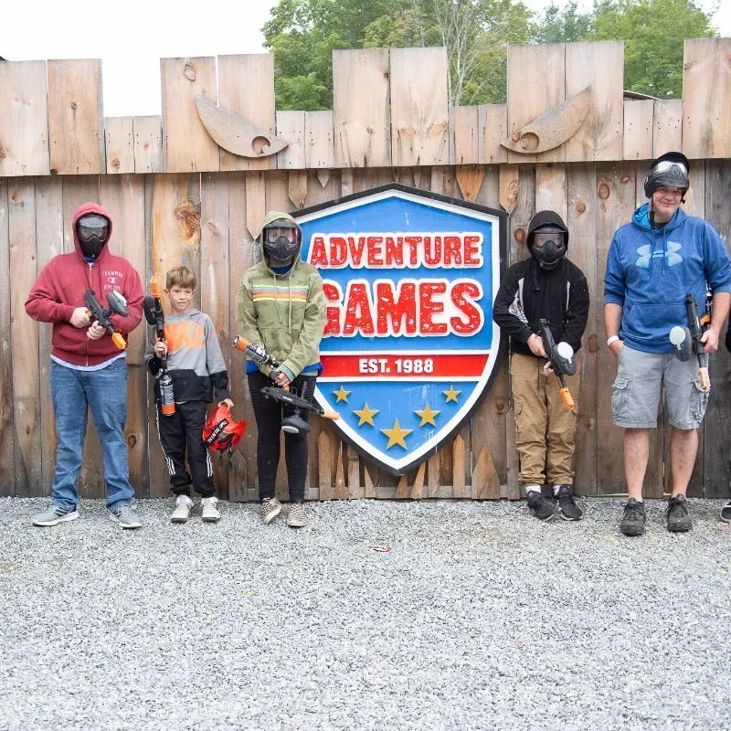 People in paintball gear stand in front of an