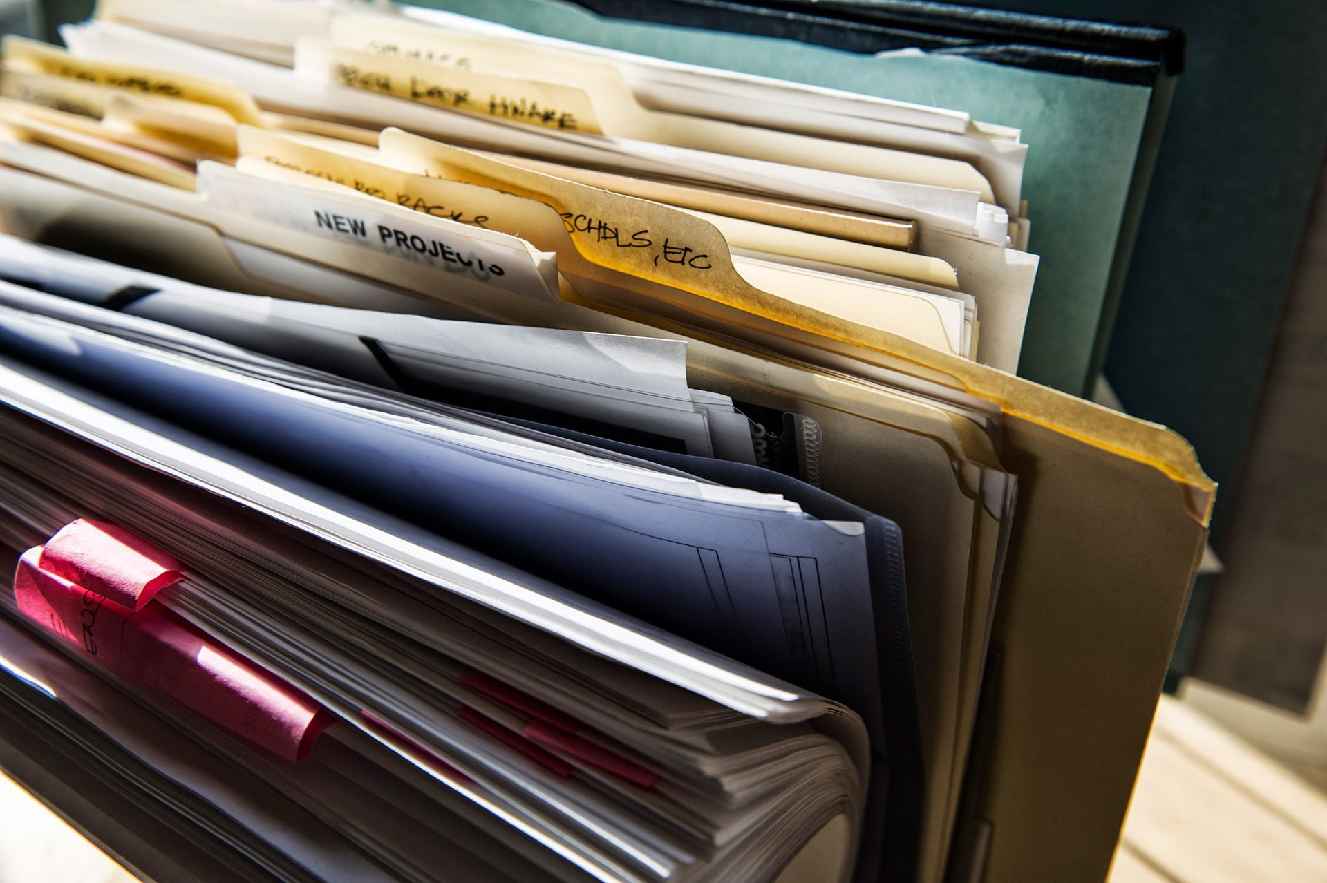 a stack of folders with one labeled ' new insurance | BXB3 Corporation | Archive Solutions in CA