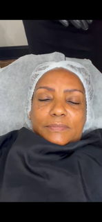 A woman is laying on a bed with her eyes closed.