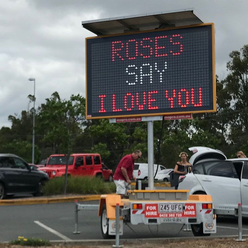 A sign that says roses say i love you