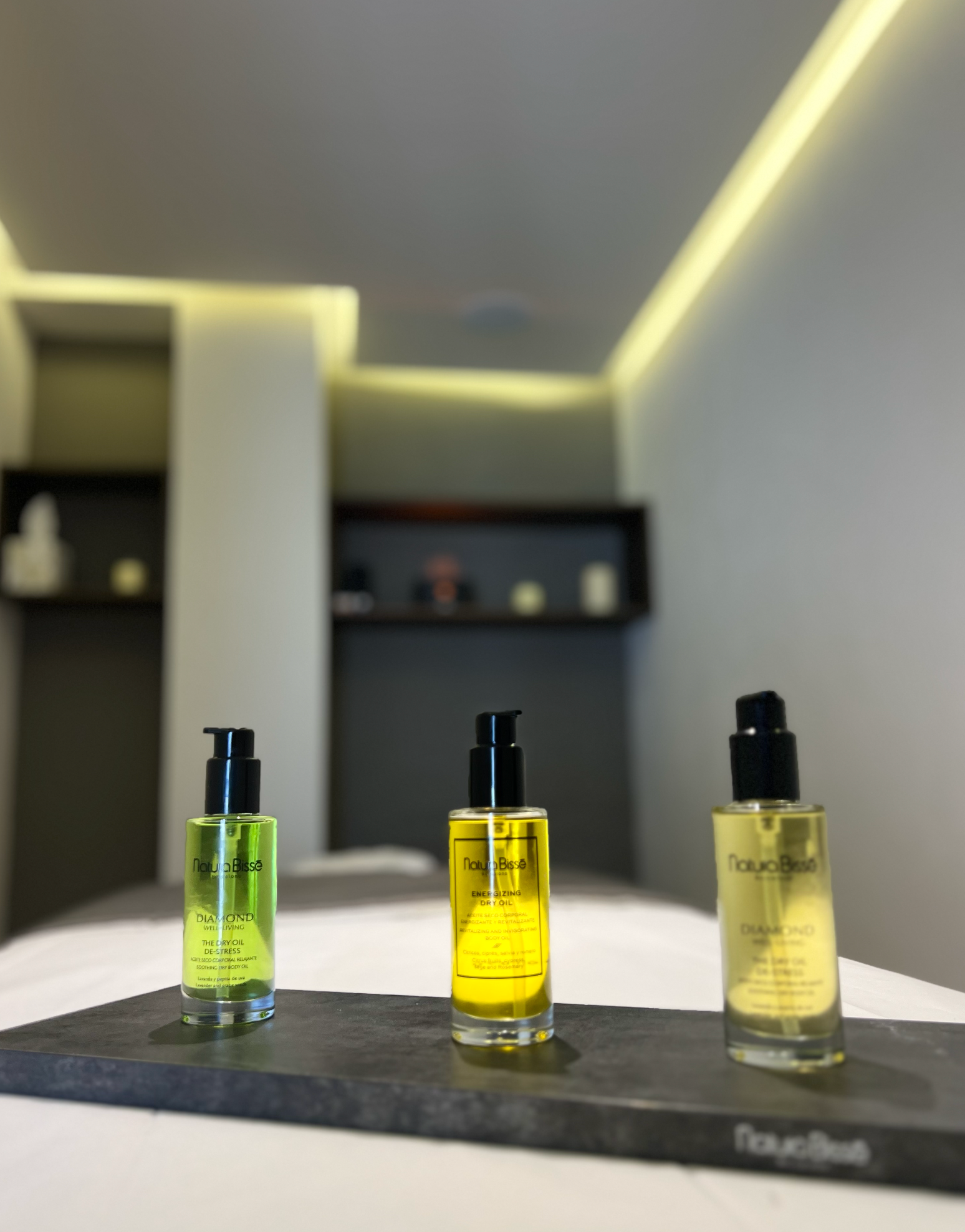 Tres frascos de perfume están sobre una mesa en una habitación.