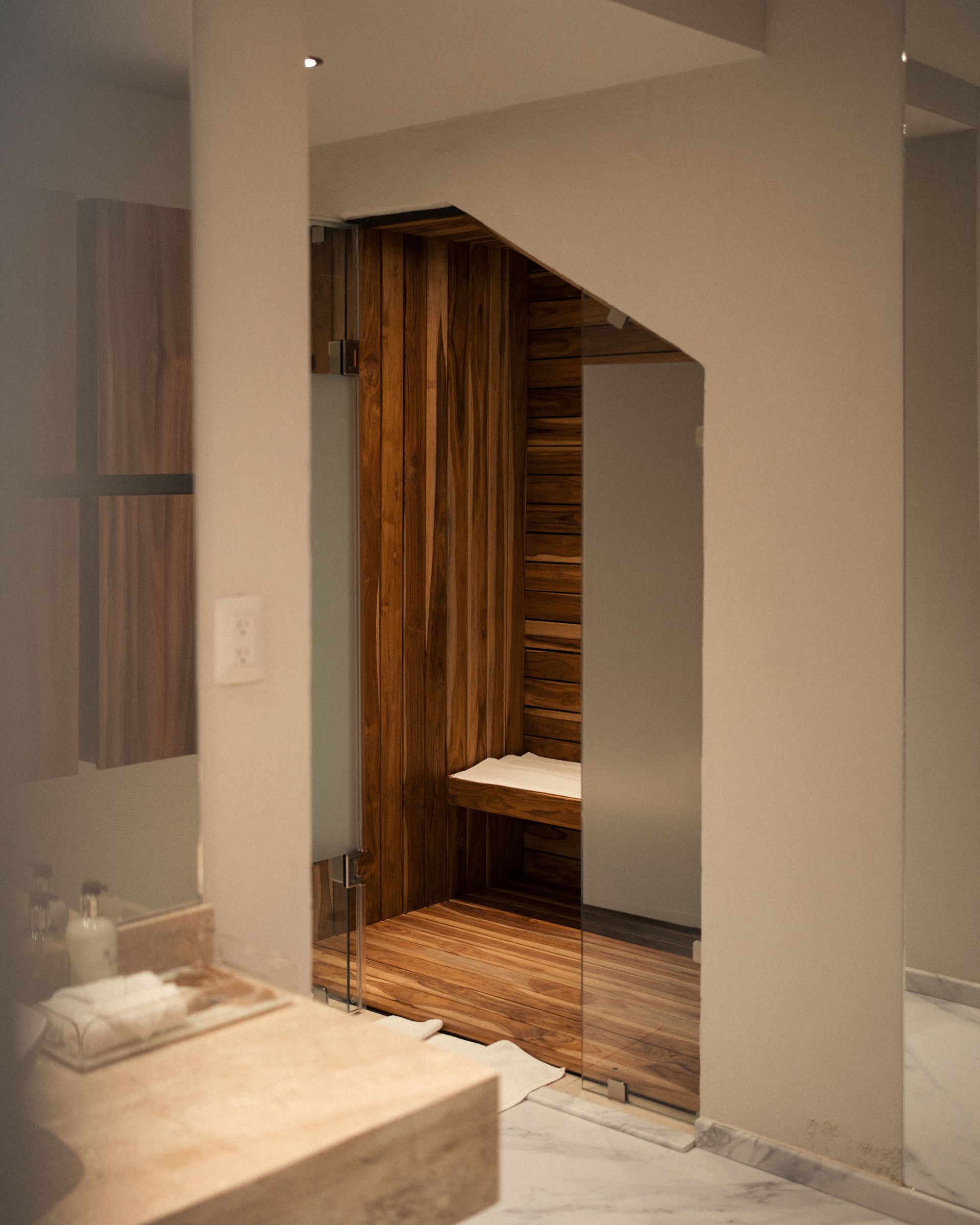 Un baño con lavabo y banco de madera.