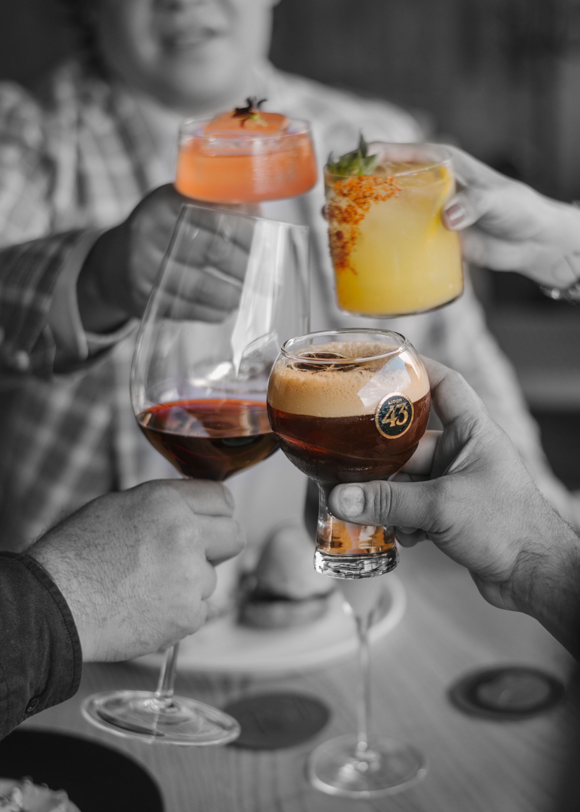 Un grupo de personas está brindando con bebidas en una mesa.