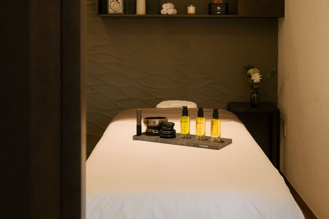 Una mesa de masajes en un spa con botellas de cosméticos sobre ella.