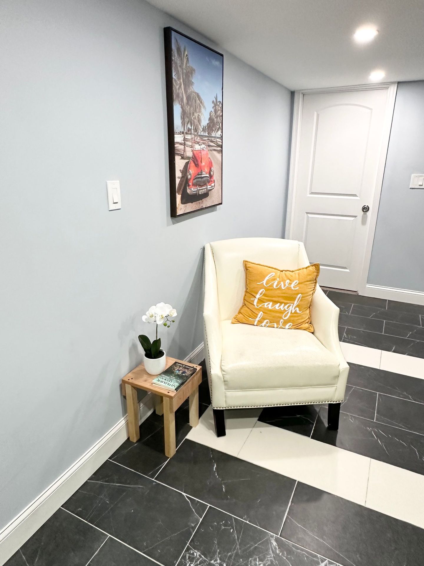 A chair with a yellow pillow on it is sitting in a hallway next to a door.