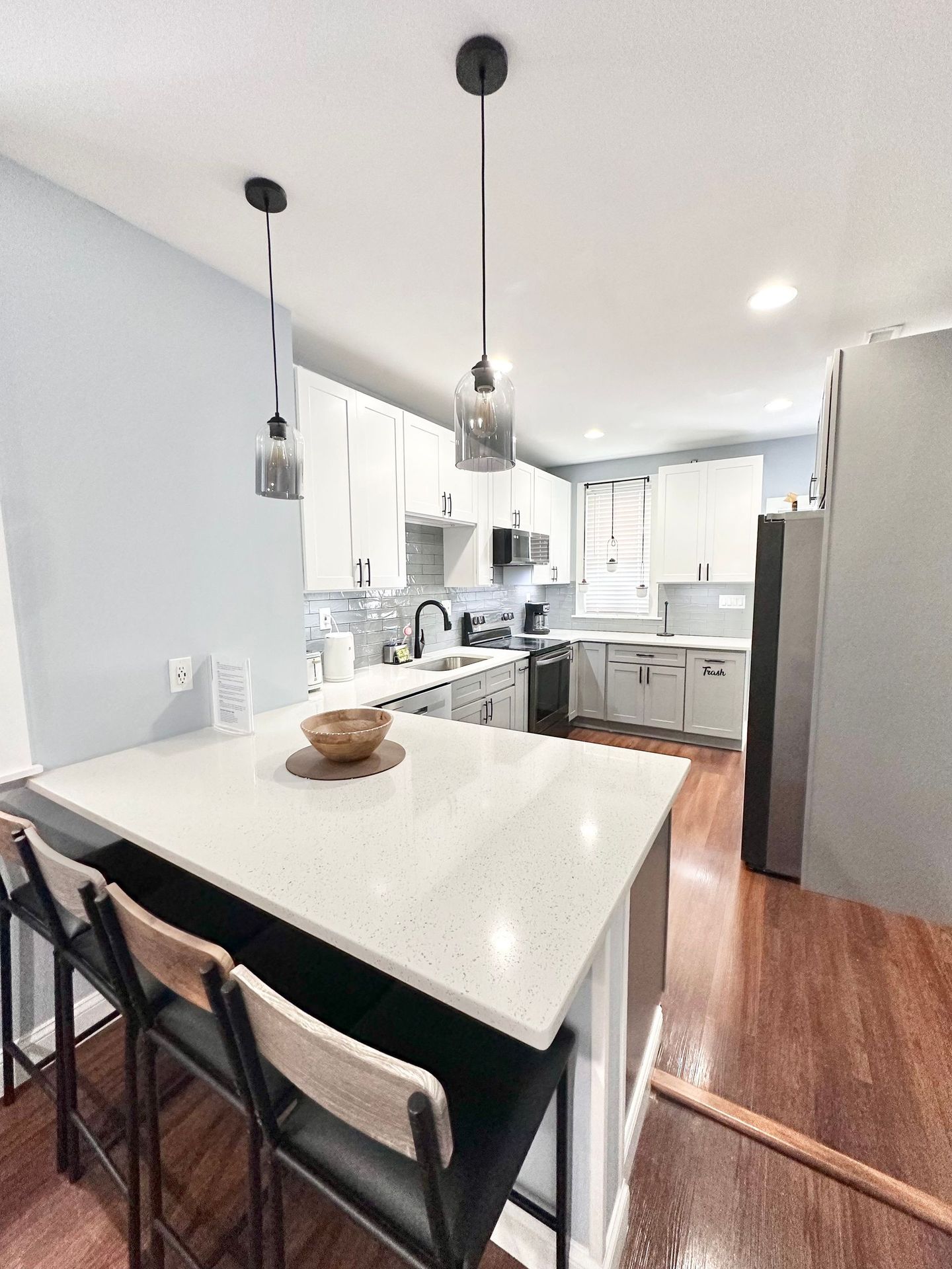 A kitchen with a large island and chairs in it