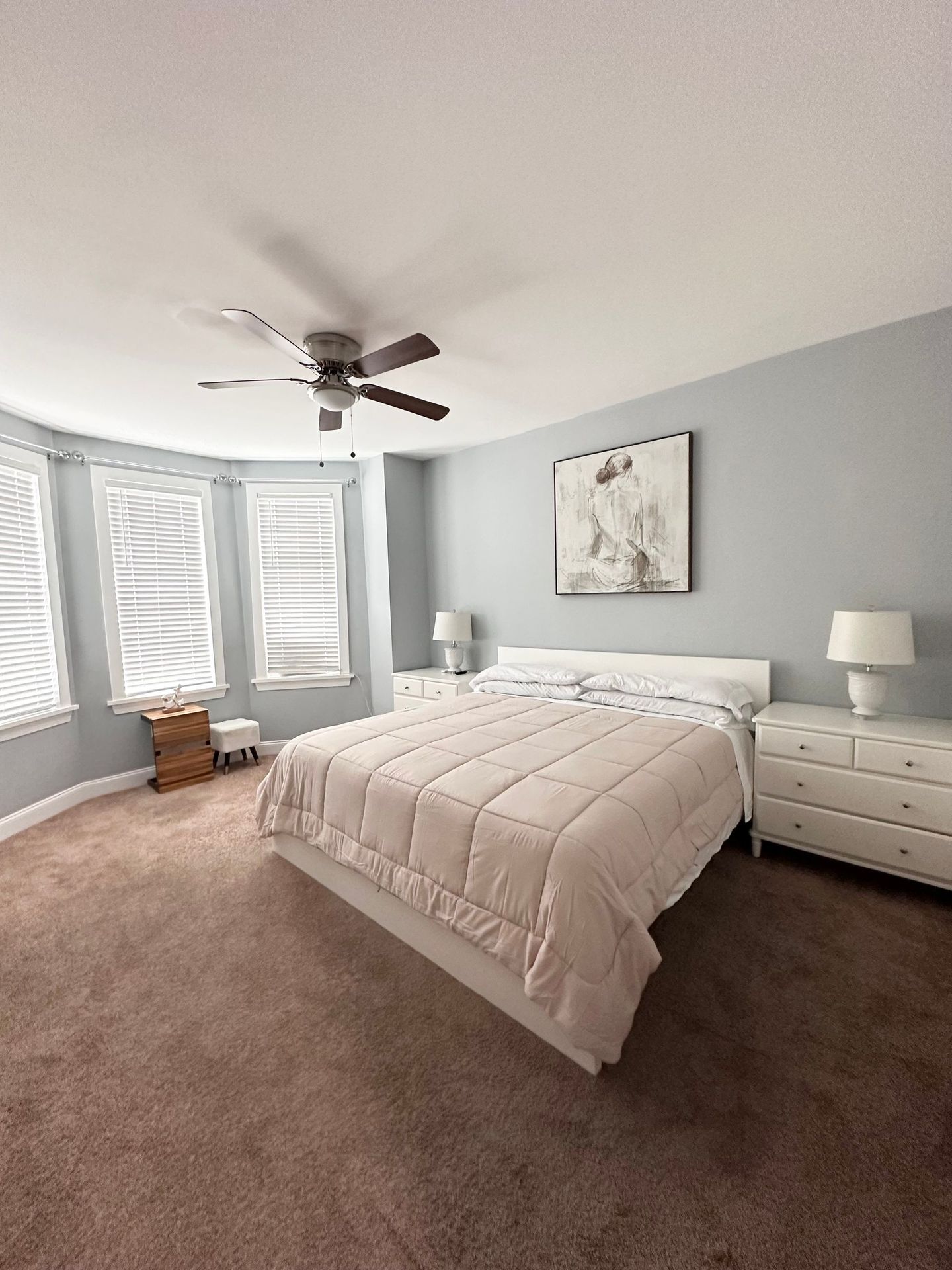 A bedroom with a large bed and a ceiling fan.