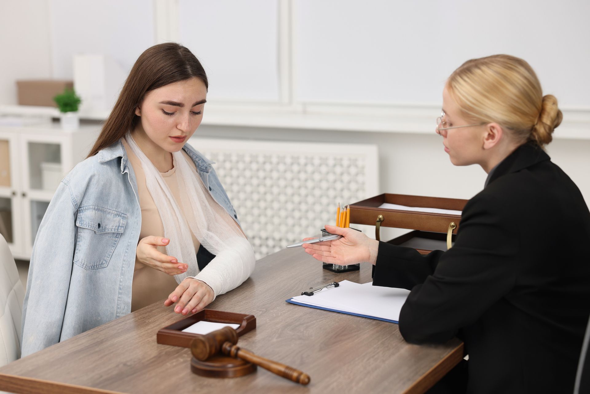 Injured woman having meeting with lawyer in office.