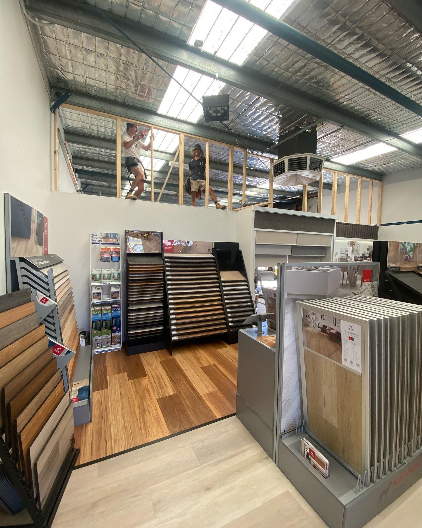 The inside of a shop with two men standing on a level — Flintoff Constructions in Charlemont, VIC