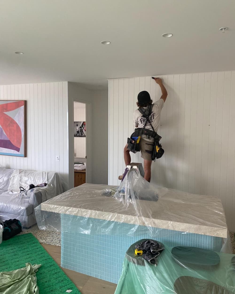 A Man Is Standing on Top of A Table in A Living Room — Flintoff Constructions in Charlemont, VIC