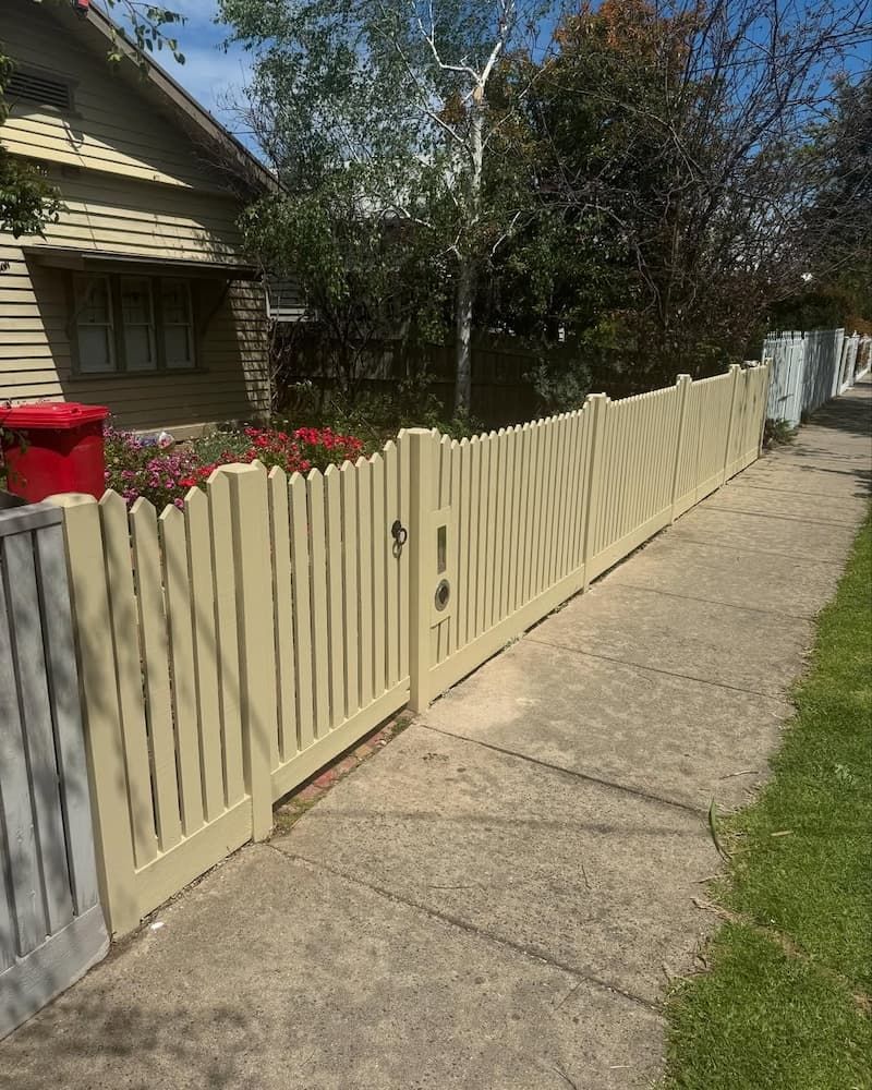A White Picket Fence Along a Sidewalk Next to A House — Flintoff Constructions in Charlemont, VIC