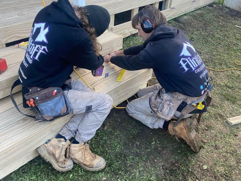 A Man and A Woman Are Working on A Wooden Deck — Flintoff Constructions in Charlemont, VIC