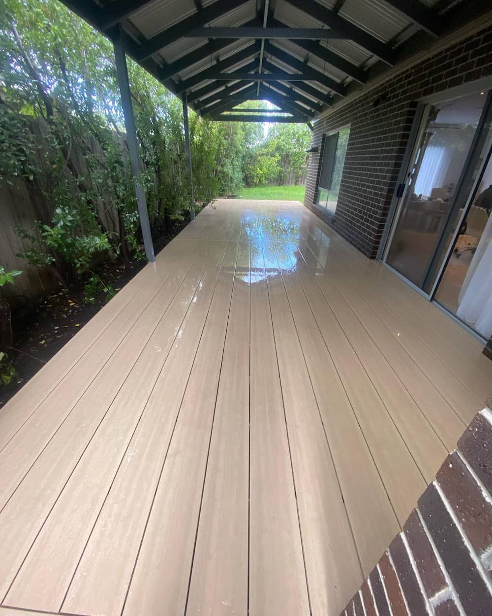 Large Wooden Deck with A Roof and A Brick Building in The Background — Flintoff Constructions in Charlemont, VIC