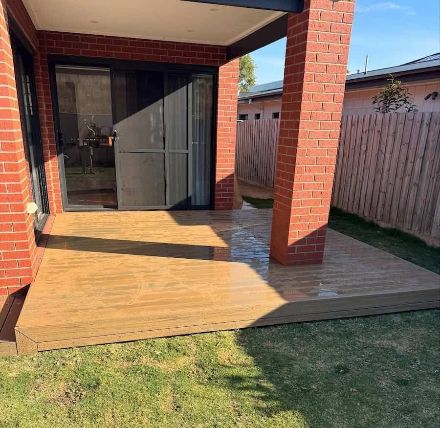 Patio with A Sliding Glass Door and A Brick Building in The Background — Flintoff Constructions in Charlemont, VIC