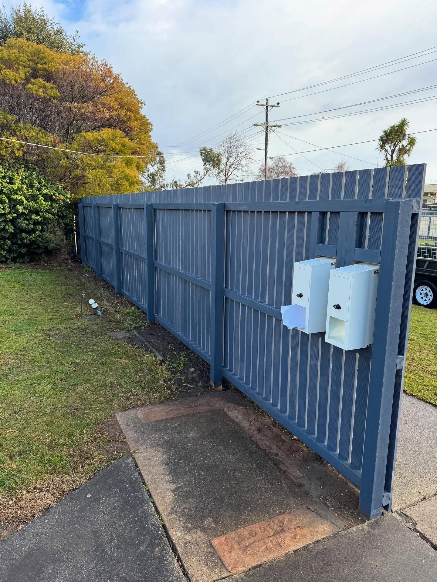 Concrete Driveway with A Blue Fence — Flintoff Constructions in Charlemont, VIC