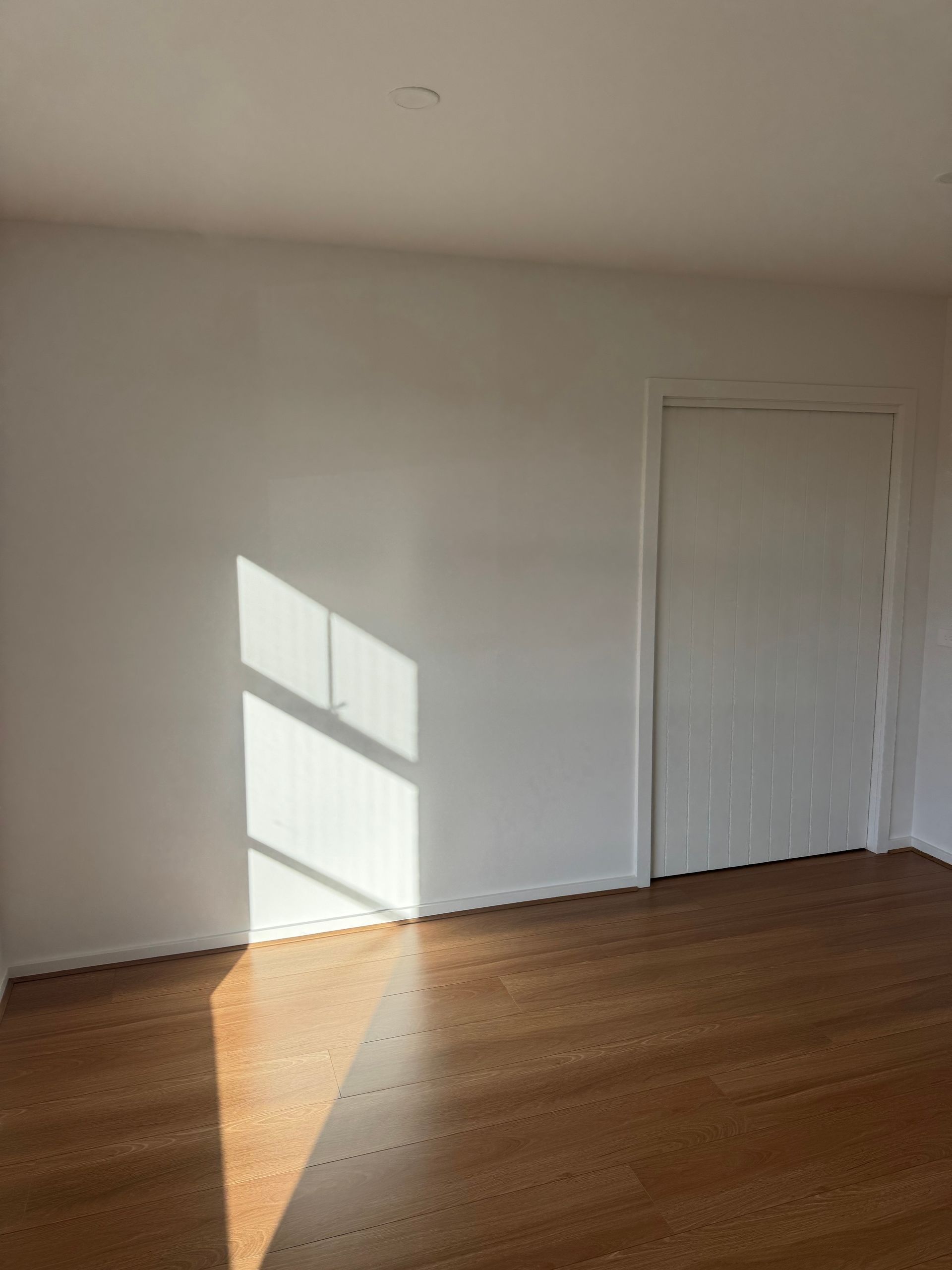 An Empty Room with White Walls, A White Door, and A Wooden Floor — Flintoff Constructions in Charlemont, VIC