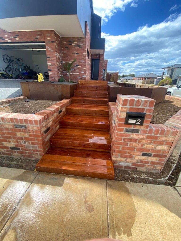 Brick Wall with Plants Growing on It in Front of A House — Flintoff Constructions in Charlemont, VIC