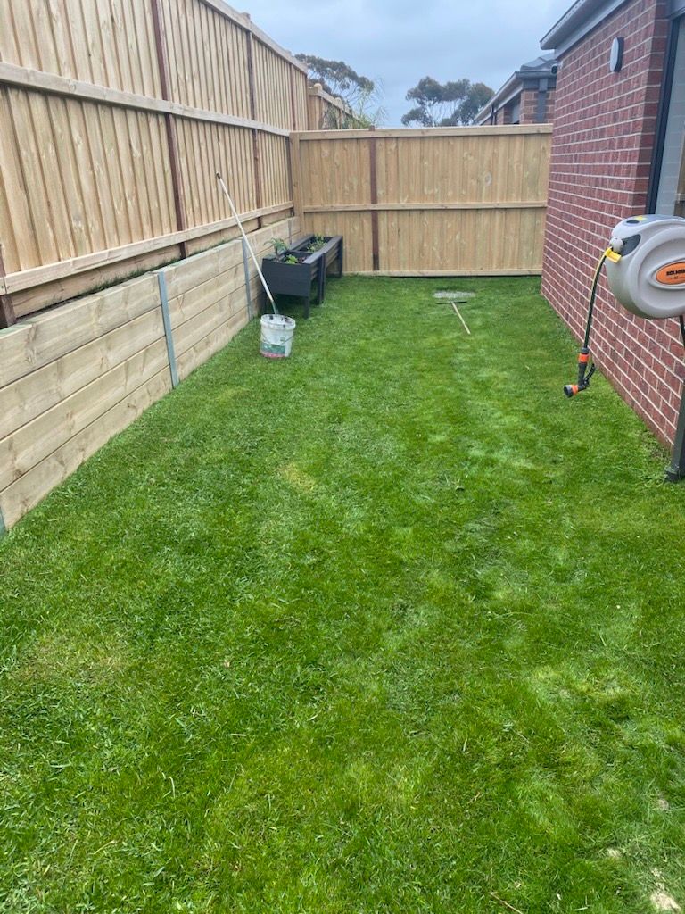 A Lawn with Rolls of Turf and A Hose in The Middle of It — Flintoff Constructions in Charlemont, VIC