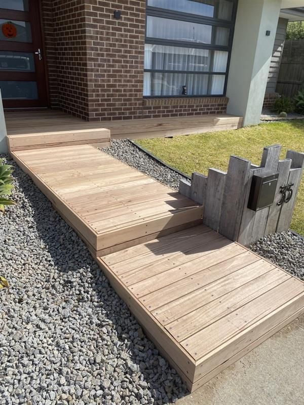 A Patio with A Pergola and Sliding Glass Doors in Front of A Brick House — Flintoff Constructions in Charlemont, VIC