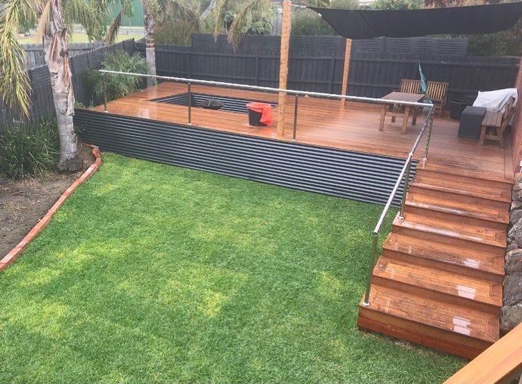 A Backyard with A Wooden Deck and Stairs Leading up To It — Flintoff Constructions in Charlemont, VIC