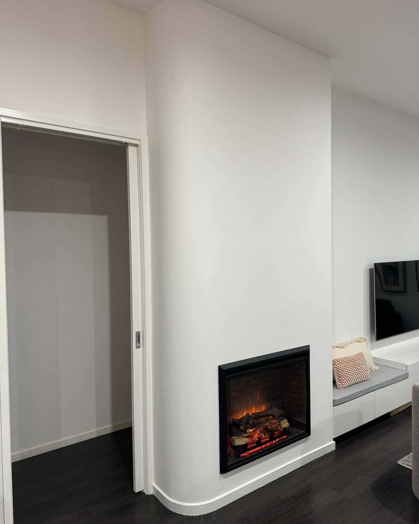 A Living Room with A Fireplace and A Television on The Wall — Flintoff Constructions in Charlemont, VIC