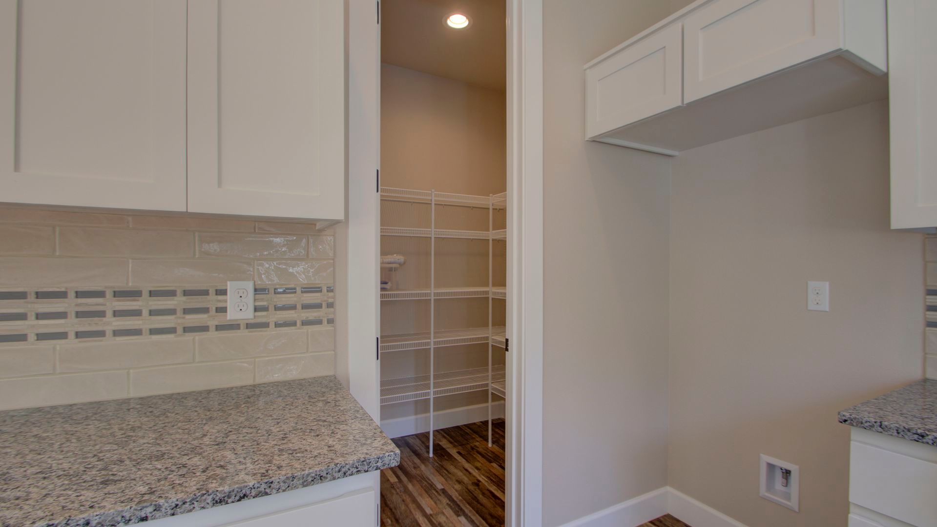 A kitchen with granite counter tops and a pantry.