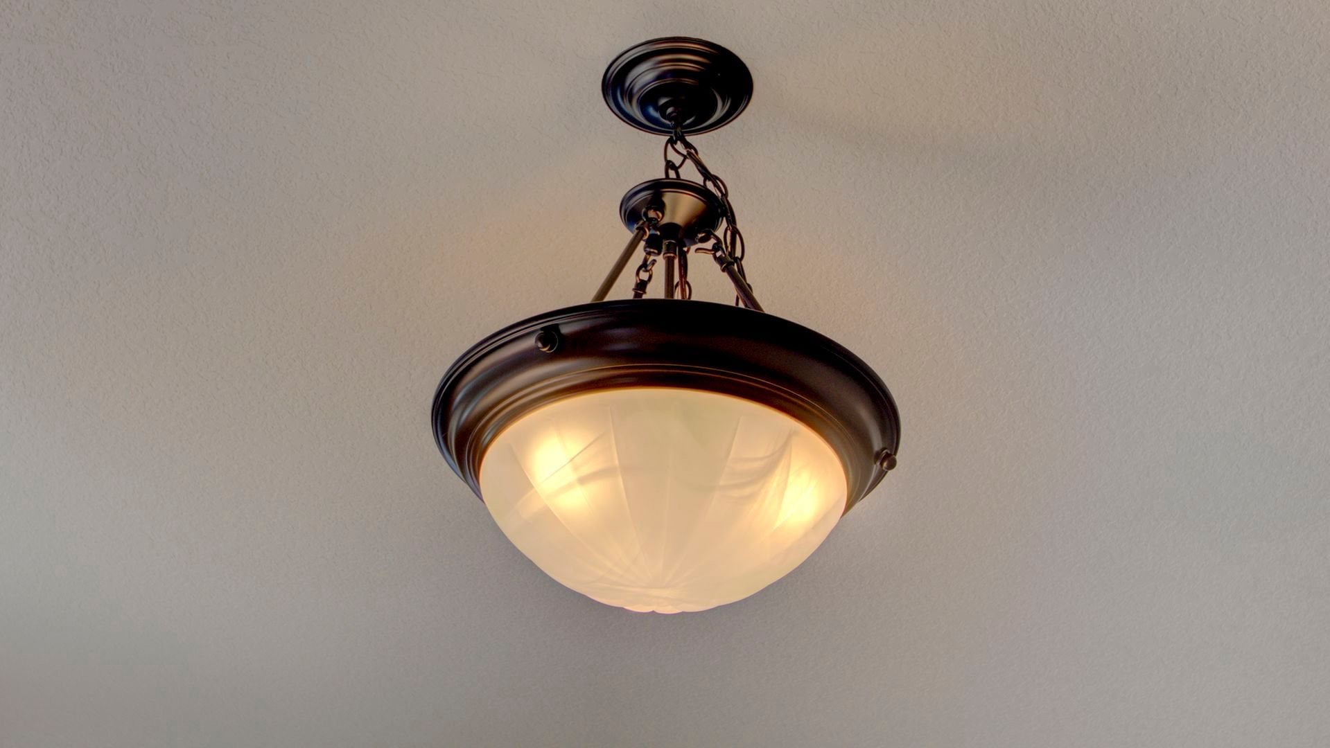 A light hanging from the ceiling with a white glass shade